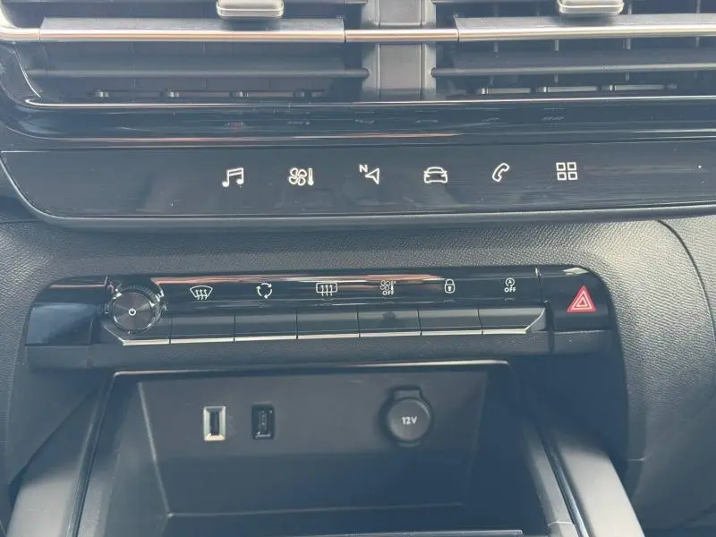 Vue rapprochée de la console centrale noire du Citroën C5 Aircross 2024 avec commandes tactiles et prises USB et 12V.