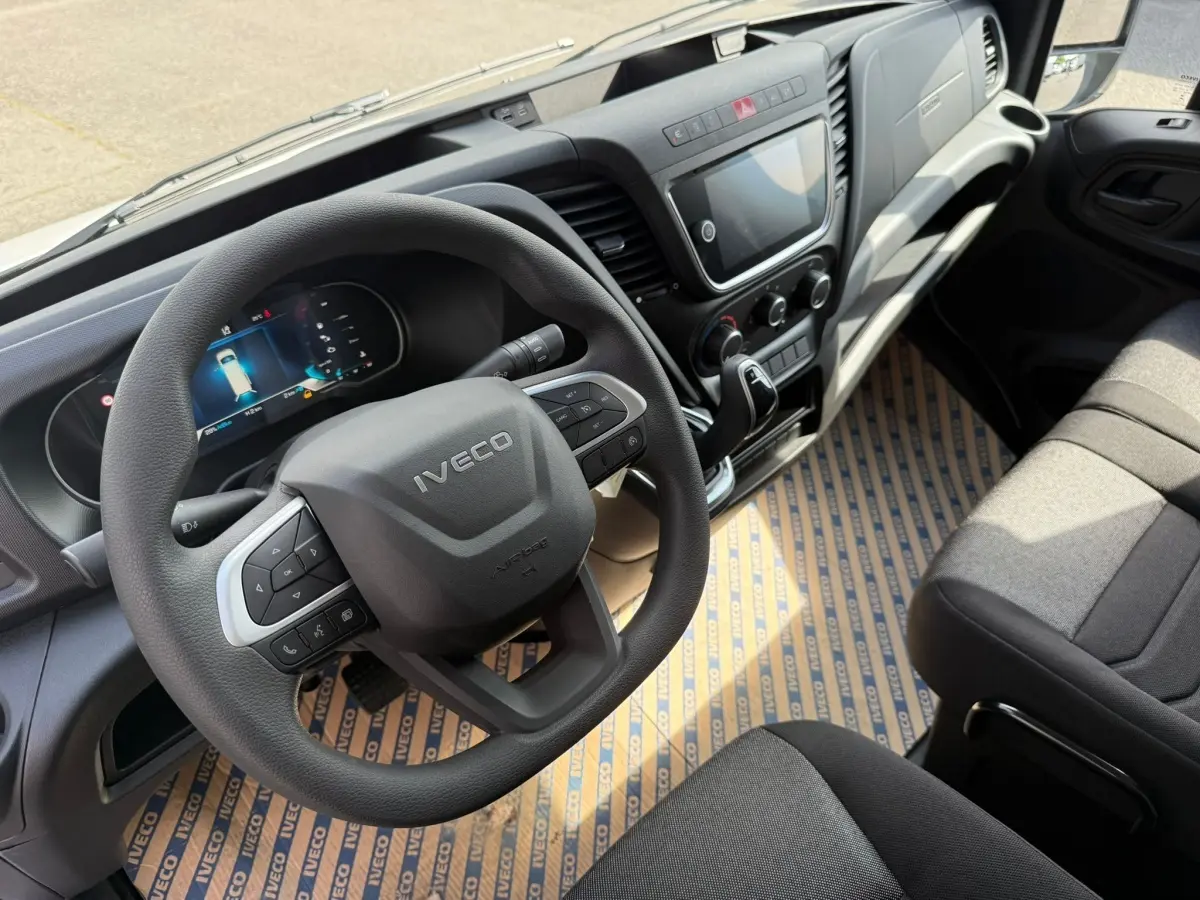 Vue intérieure du poste de conduite de l’Iveco Daily 2026, volant multifonction et tableau de bord numérique visibles.