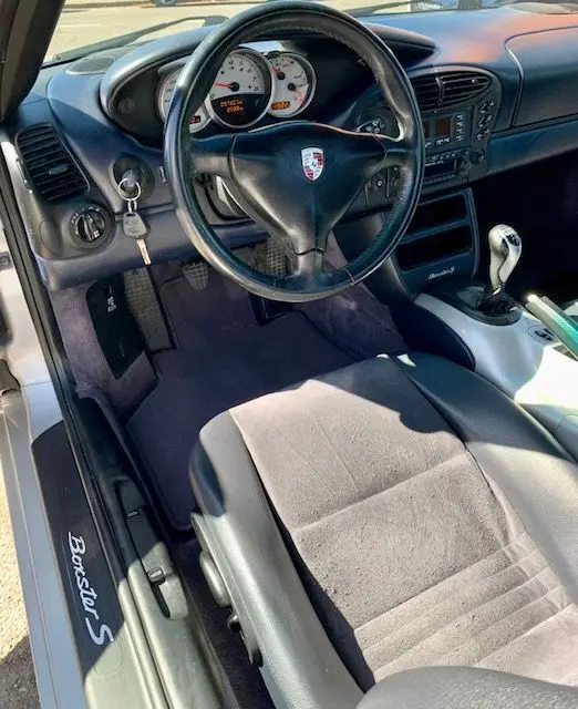 Intérieur de Porsche Boxster 986 3.2 S 2001, vue côté conducteur, volant noir, tableau de bord et levier de vitesse manuelle visibles.