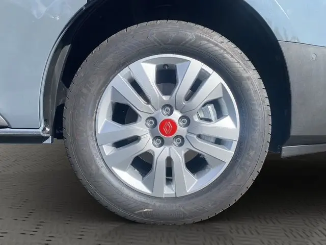 Gros plan sur la jante alliage 17'' silver avec logo rouge Renault, montée sur un Renault Trafic gris urbain côté droit.