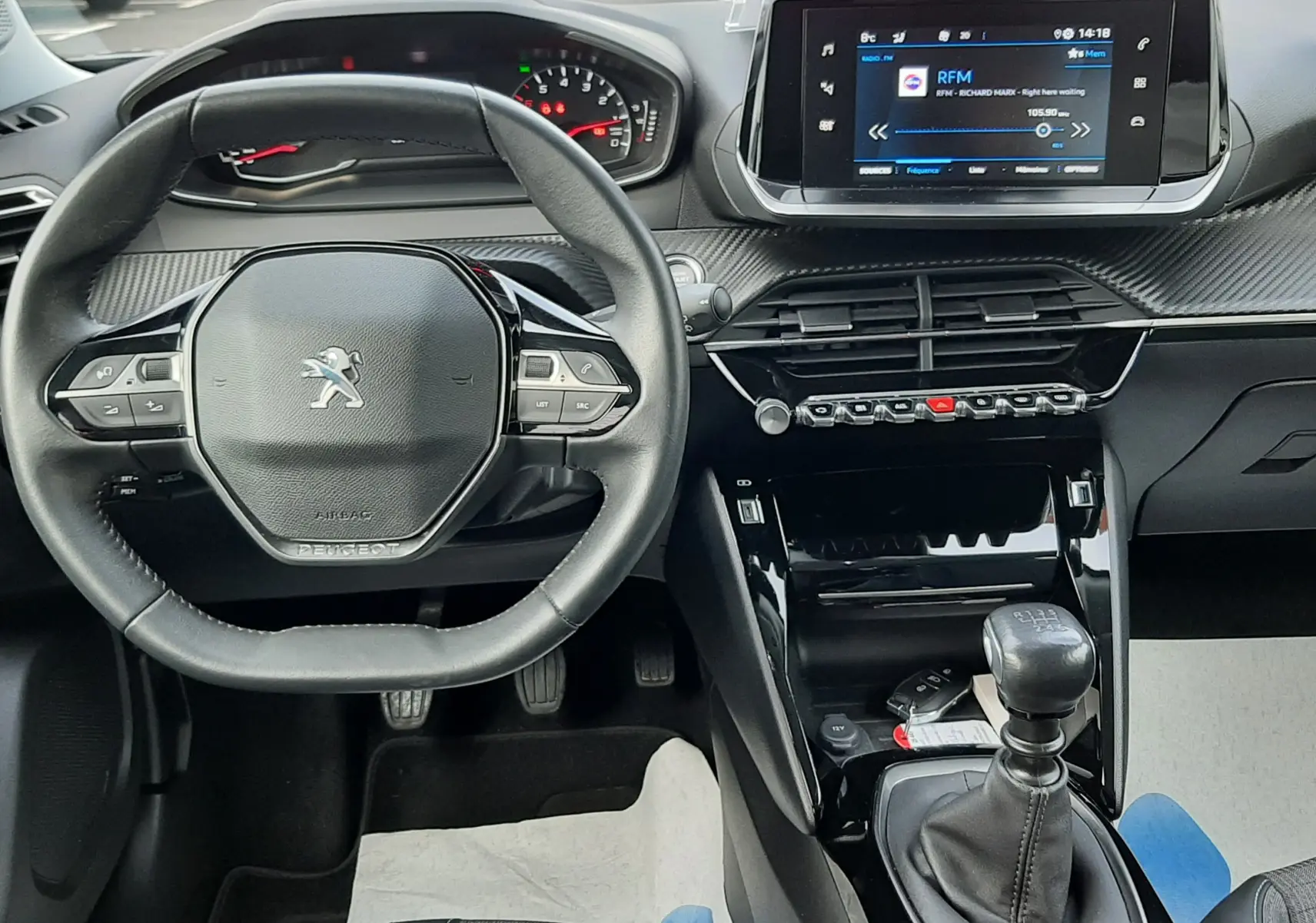 Intérieur noir du Peugeot 2008 1.5 BlueHDi 110 Allure 2021, vue centrée sur le volant et la console avec boîte manuelle.
