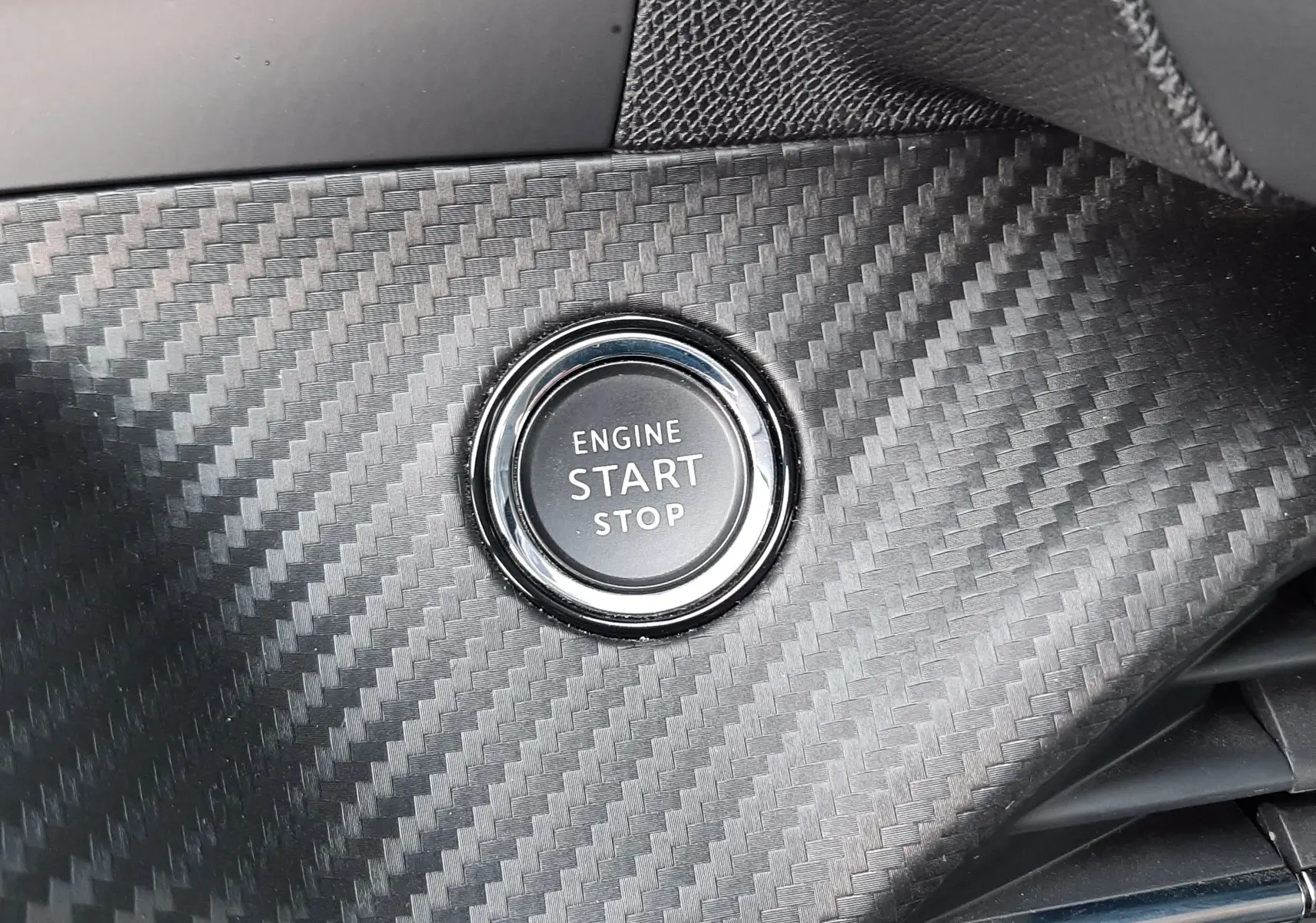 Bouton démarrage moteur circulaire sur tableau de bord effet carbone intérieur Peugeot 2008 gris 2021 finition Allure.