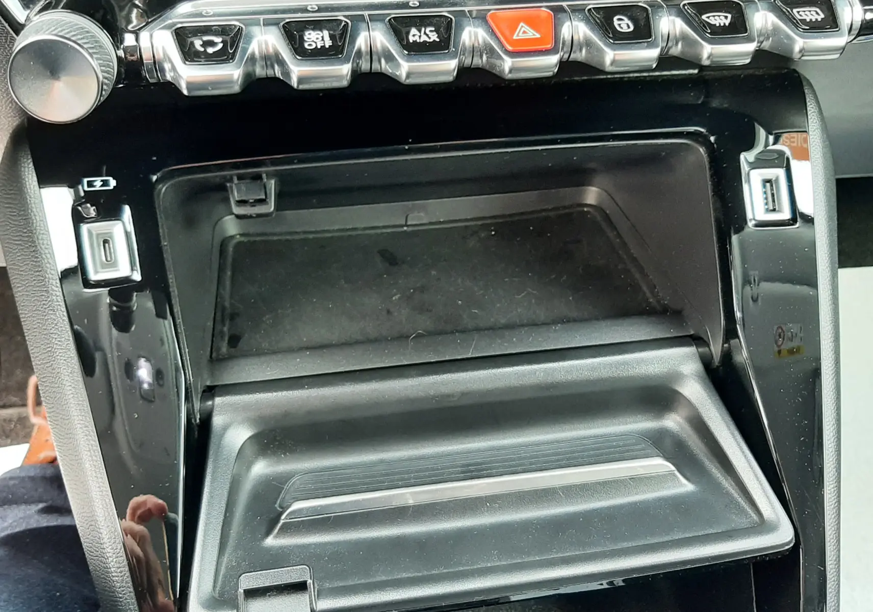 Vue rapprochée de la console centrale noire du Peugeot 2008 1.5 BlueHDi 110 Allure 2021 avec rangements et boutons chromés.