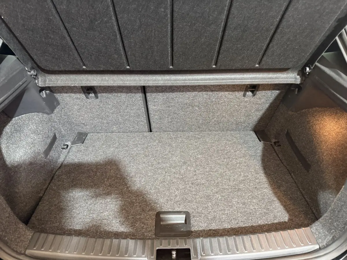 Vue intérieure du coffre gris d'une SEAT Ibiza 1.0 TSI 110 FR 2024, montrant l'espace de rangement et la banquette arrière rabattable.