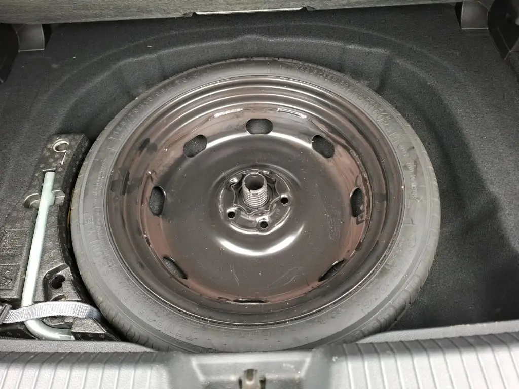 Vue rapprochée de la roue de secours noire dans le coffre d'une Volkswagen Golf 1.5 eTSI 130 DSG7 Active gris 2022.