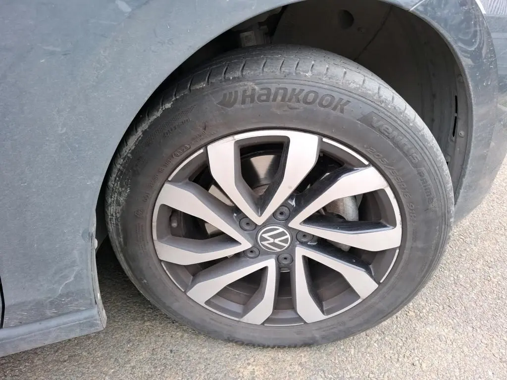 Gros plan sur la roue avant gauche grise d'une Volkswagen Golf 1.5 eTSI 130 DSG7 Active avec jante alliage distinctive.