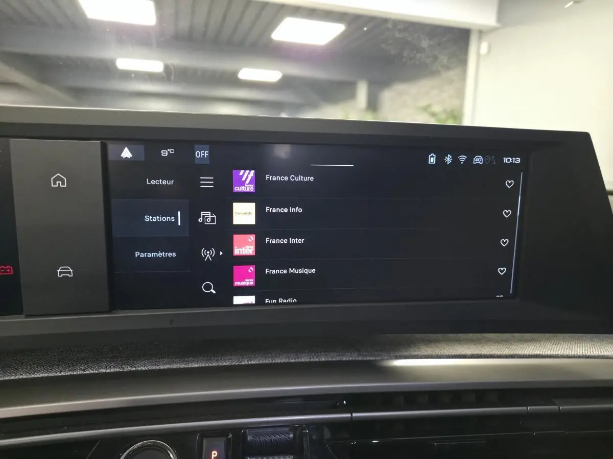 Écran tactile central du Peugeot 3008 noir hybride 2025 affichant les stations radio dans un intérieur moderne.