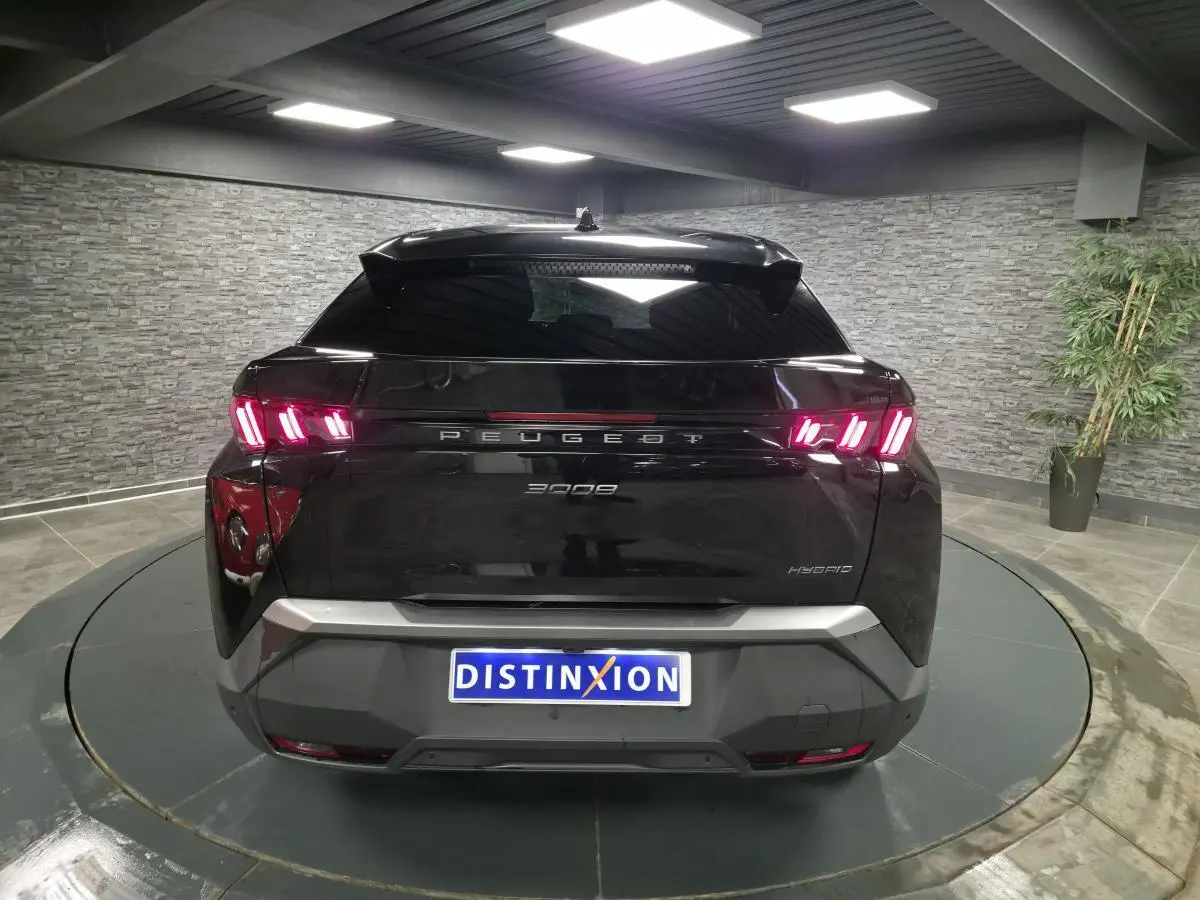 Vue arrière d'un Peugeot 3008 noir hybride avec feux arrière LED 3 griffes et bandeau noir laqué.