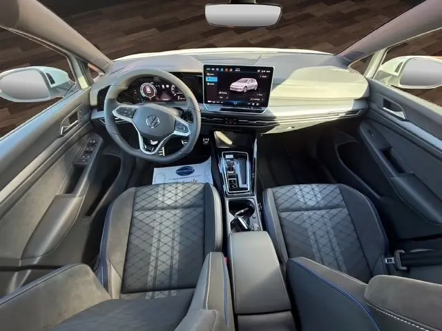 Vue intérieure avant de la Volkswagen Golf 2.0 TDI blanche, avec tableau de bord numérique et écran tactile central.