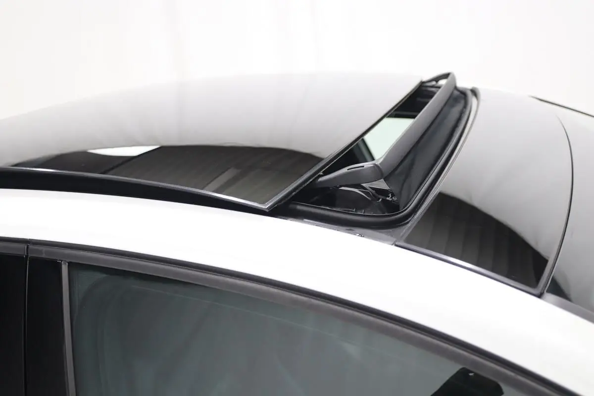 Toit panoramique partiellement ouvert sur le côté gauche d'une Volkswagen Golf blanche vue de dessus.