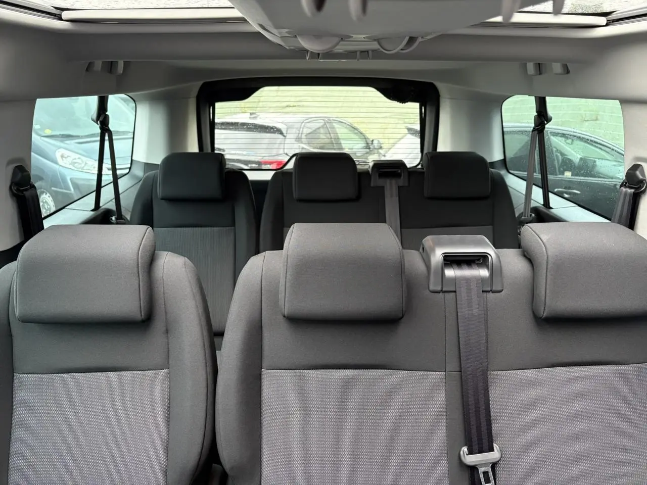 Vue intérieure arrière de l'Opel Zafira Life XL gris Artense, montrant les sièges 9 places et le toit panoramique.