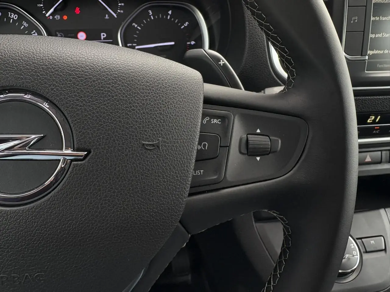 Gros plan sur le volant en cuir noir de l'Opel Zafira Life XL 2024 avec commandes intégrées et tableau de bord partiel.