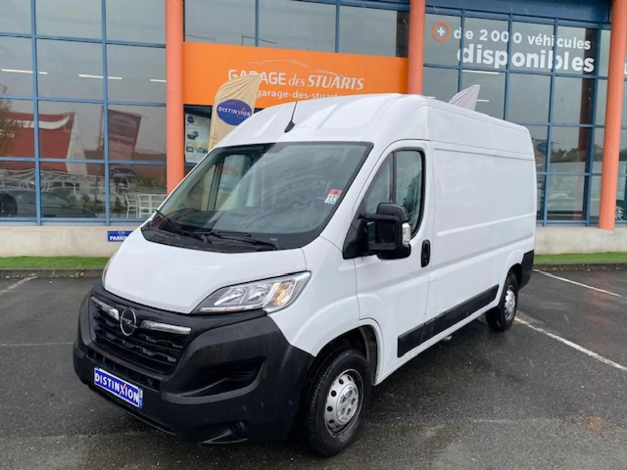 Opel Movano Fourgon blanc vu en 3/4 avant droit, avec calandre noire et rétroviseurs électriques dégivrants.