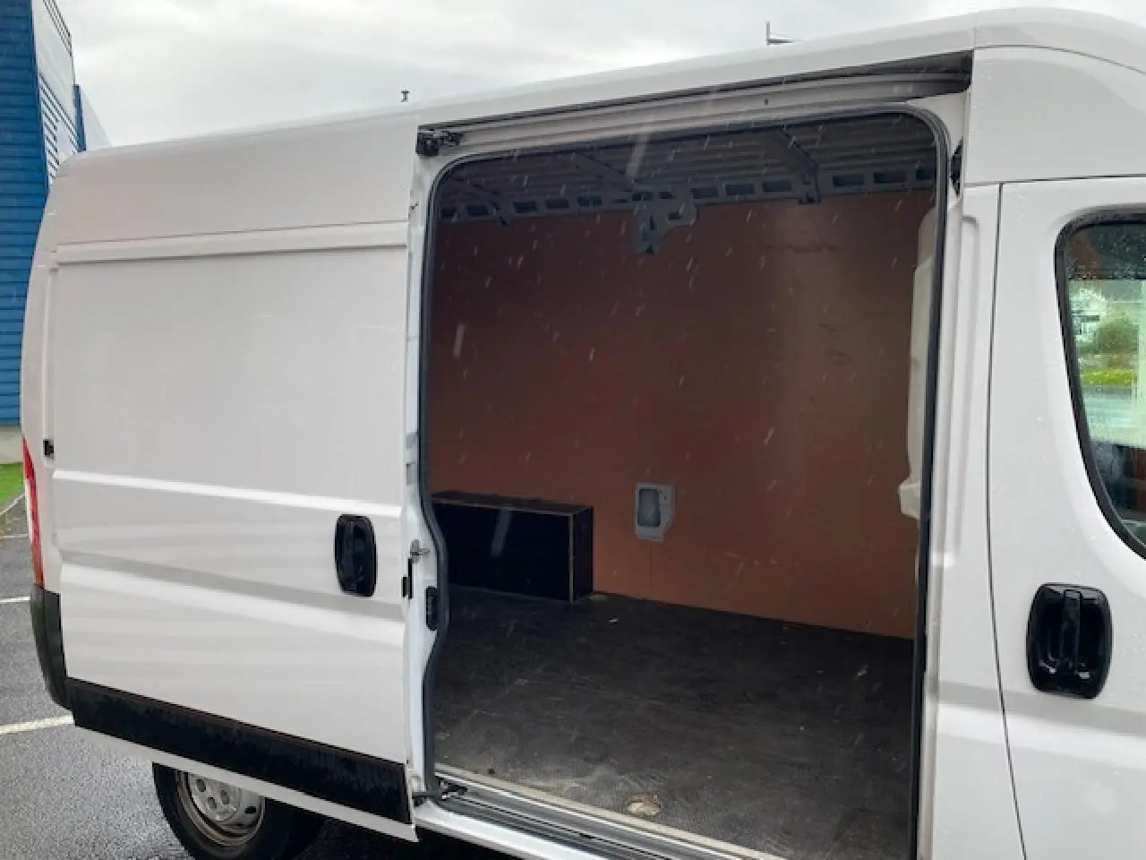 Vue latérale droite d’un Opel Movano Fourgon blanc 2023 avec porte coulissante ouverte sur l’espace de chargement vide.