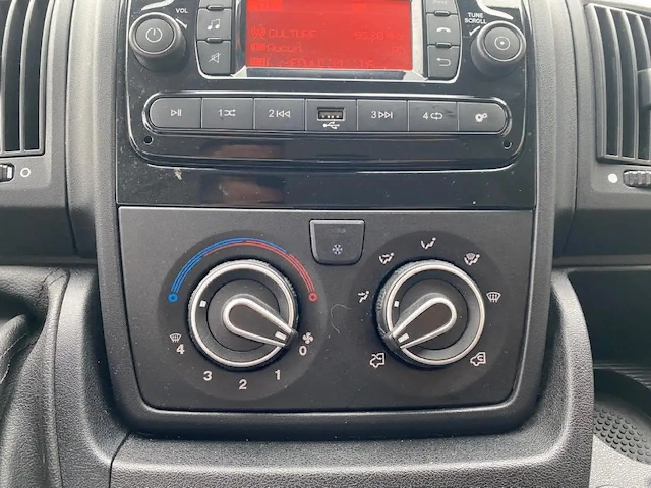 Vue rapprochée du tableau de bord de l'Opel Movano Fourgon 2023, montrant les commandes de climatisation manuelle.