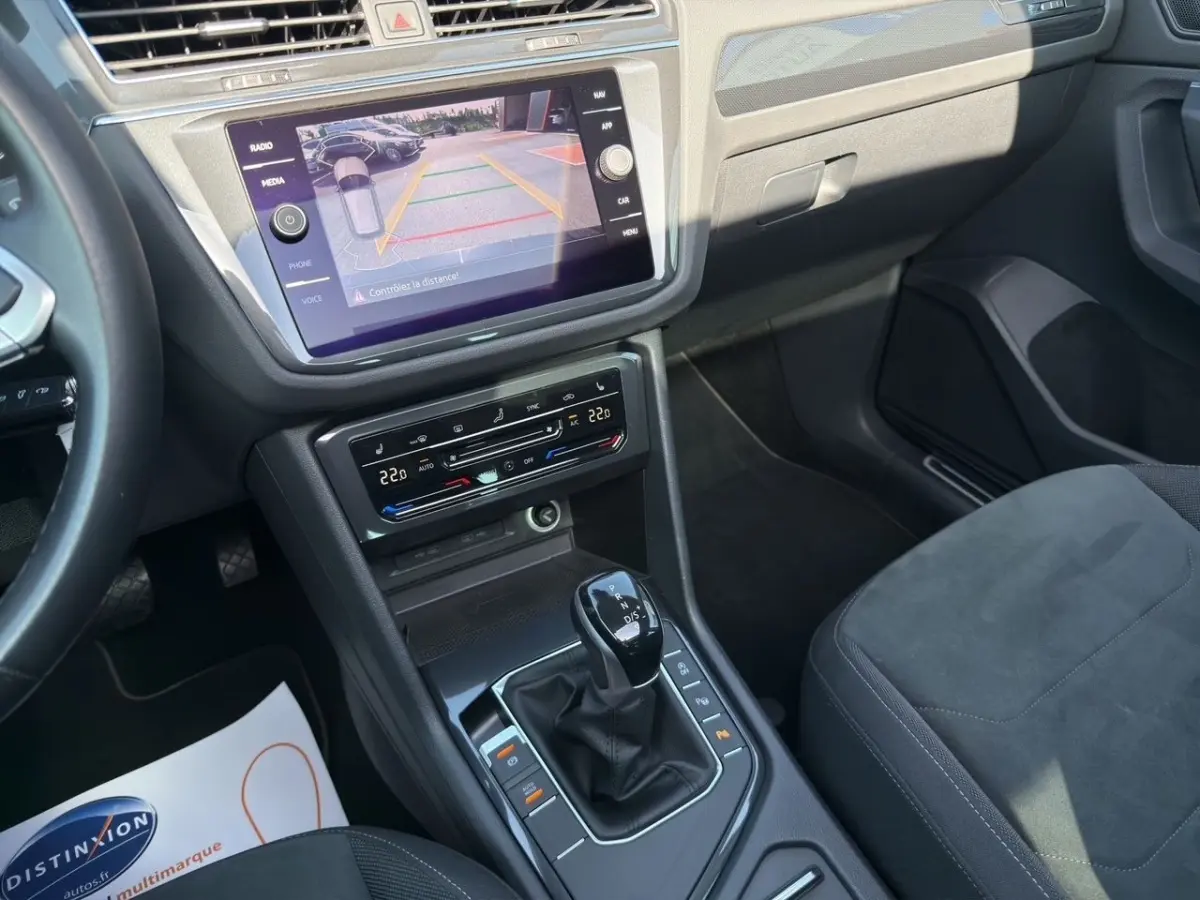 Vue intérieure du Volkswagen Tiguan 2022 noir, console centrale avec écran tactile et levier de boîte automatique DSG7.