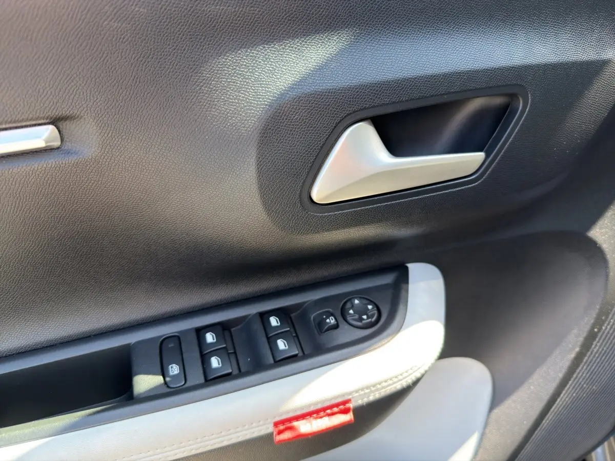 Détail de la porte côté conducteur de la Citroën C3 2025, avec commandes électriques et garniture bi-ton gris foncé et clair.