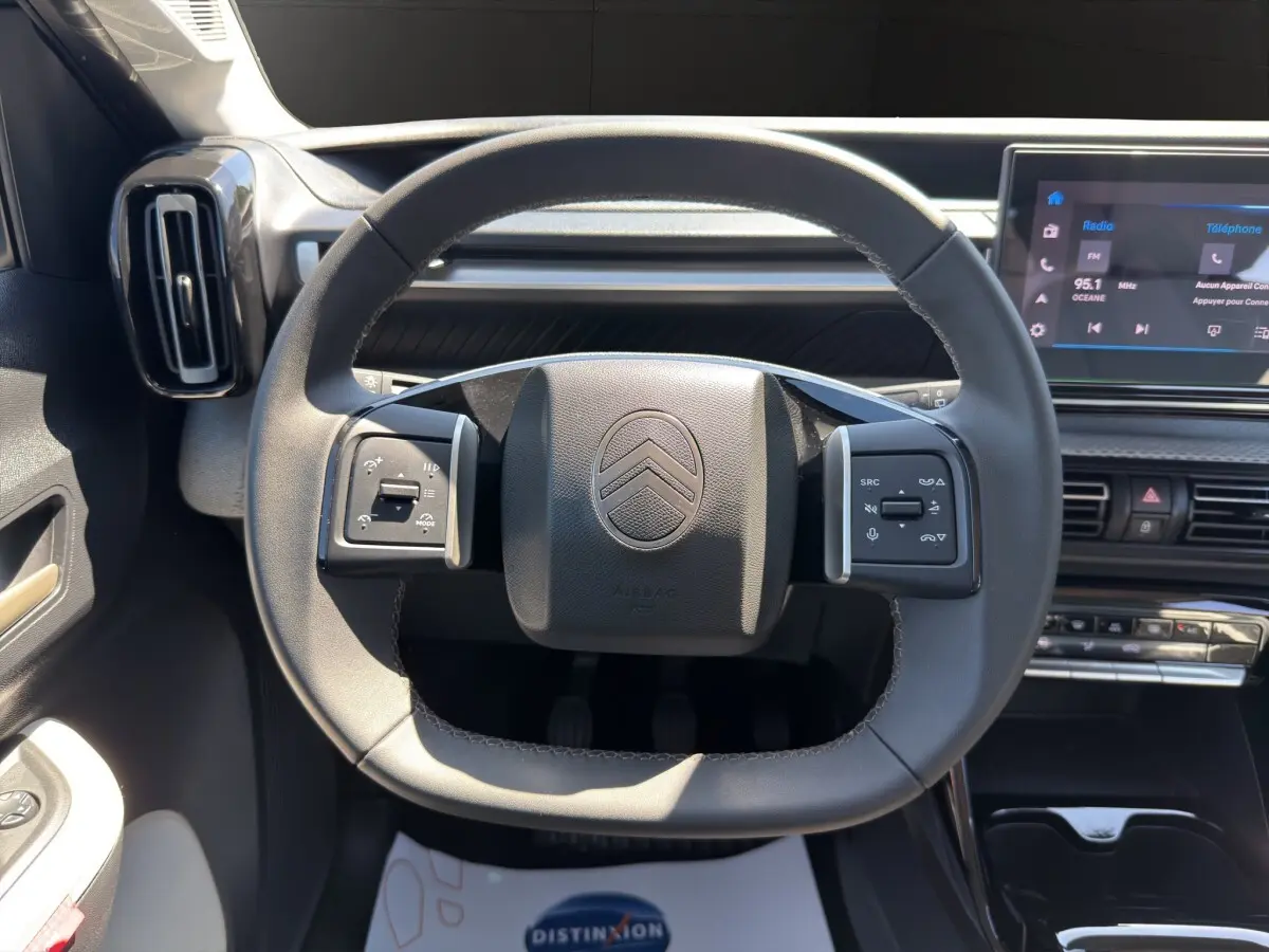 Vue rapprochée du volant cuir noir de la Citroën C3 Turbo 100 BVM6 MAX avec tableau de bord et écran tactile visible.