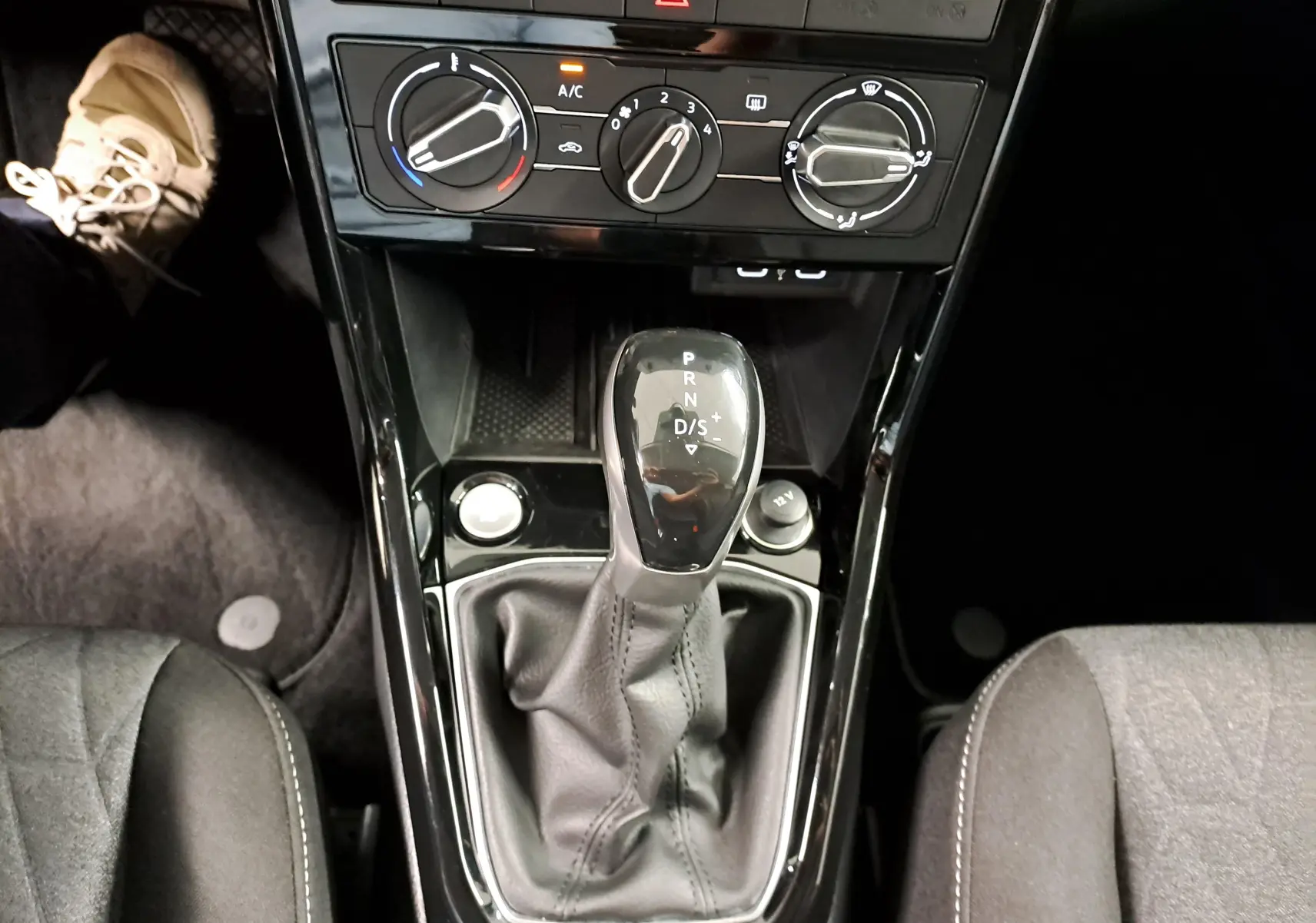 Gros plan sur la console centrale du Volkswagen T-Cross 2025 avec levier de vitesse automatique et commandes de climatisation.