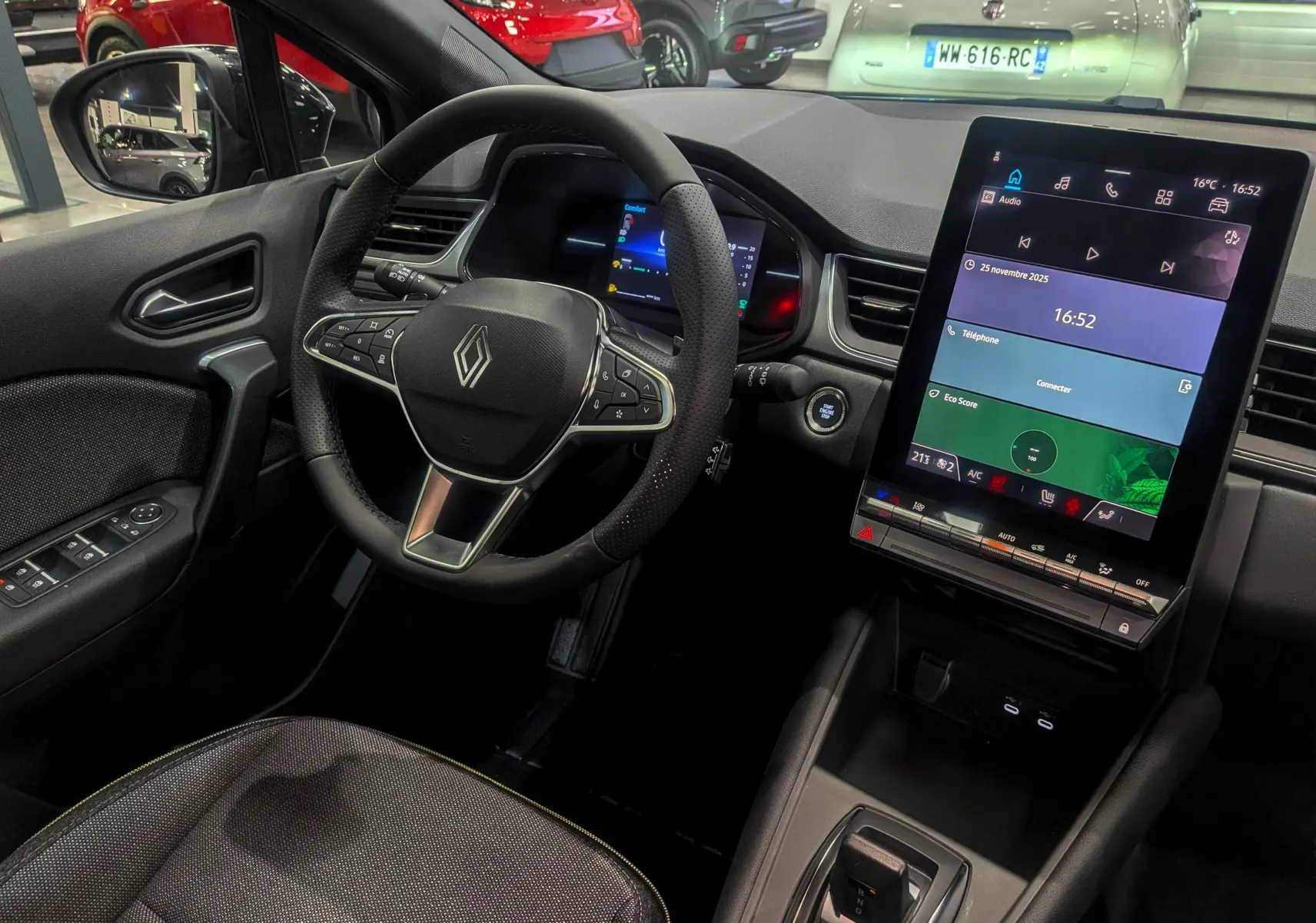 Vue intérieure du tableau de bord du Renault Captur gris Cassiopé 2025, avec volant multifonction et écran tactile vertical.