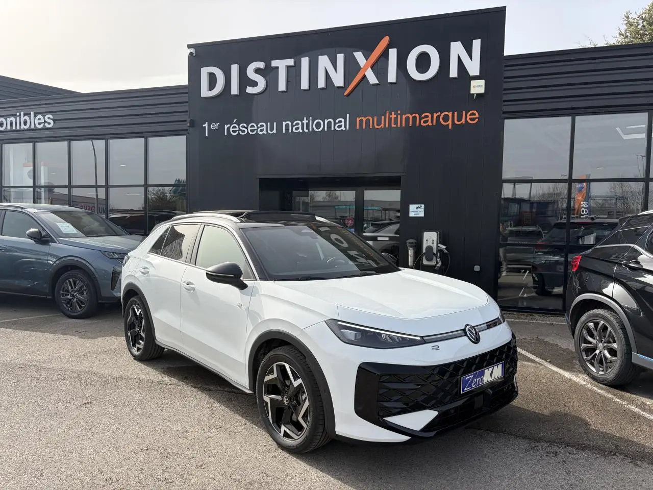 Volkswagen T-Roc blanc pur toit noir en 3/4 avant droit avec jantes noires et calandre noire brillante.