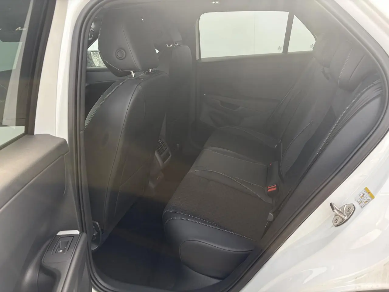 Vue intérieure côté gauche de la banquette arrière en tissu et cuir noir du Volkswagen T-Roc blanc toit noir 2026.