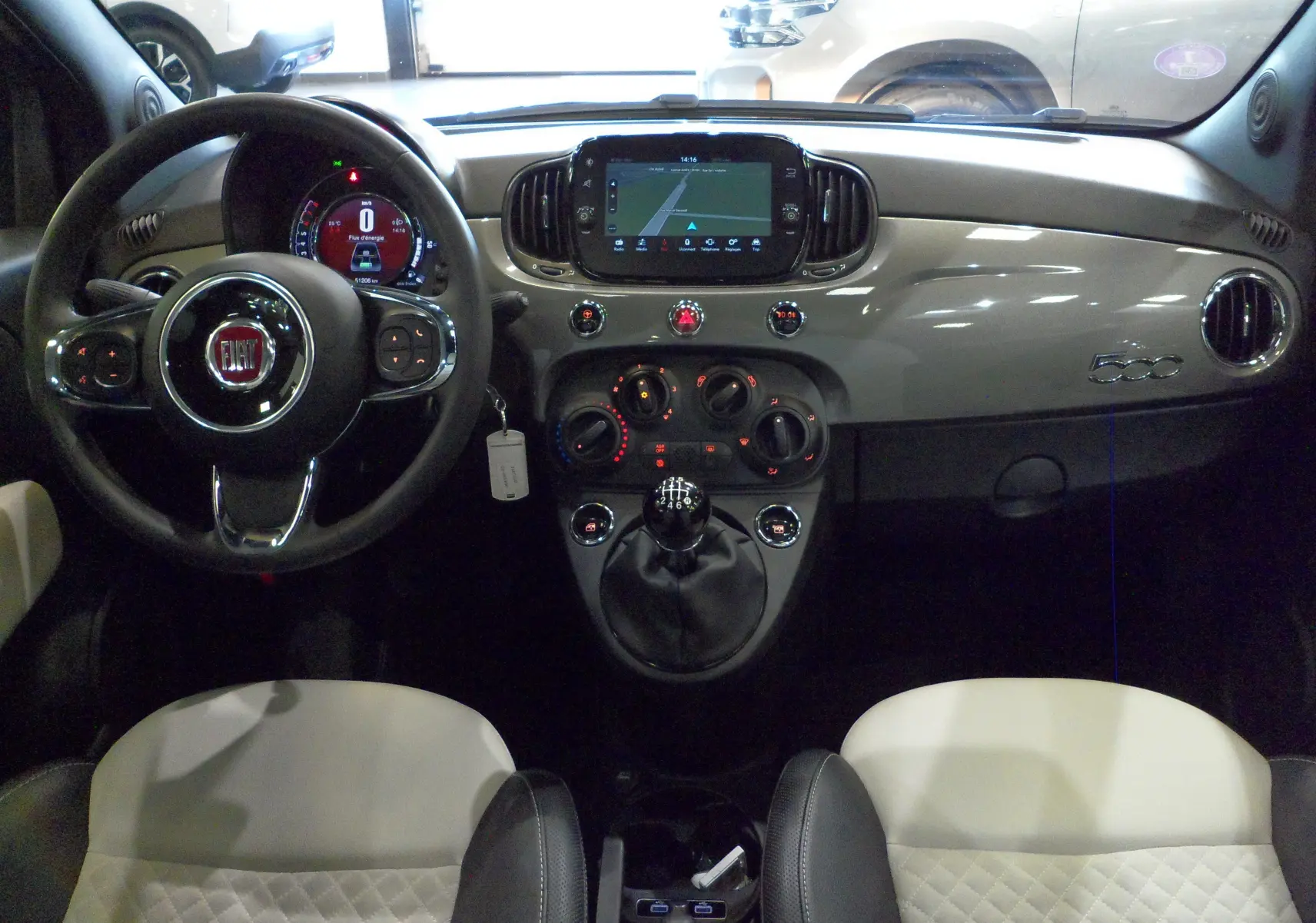 Vue intérieure avant de la Fiat 500 Electroclash Grey 2021, tableau de bord brillant avec écran tactile et volant multifonction.