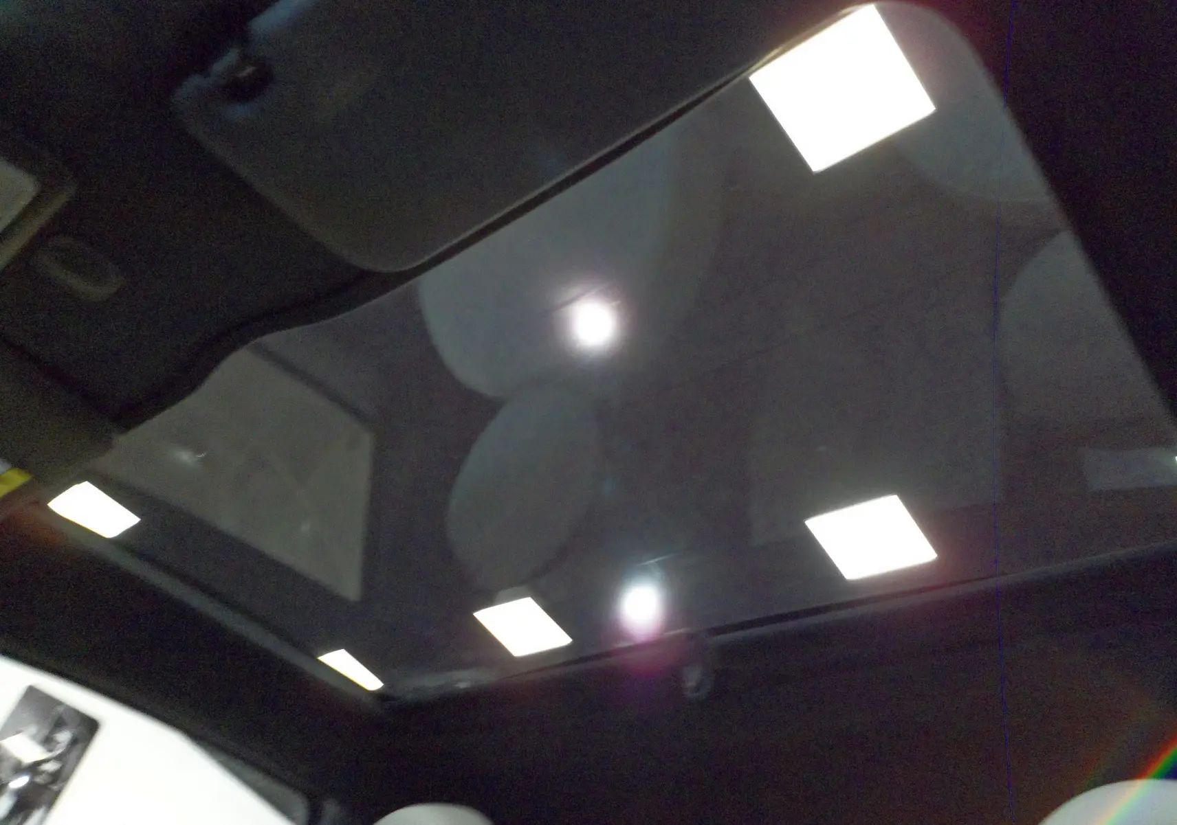 Toit panoramique en verre de la FIAT 500 Electroclash Grey, vue intérieure vers le ciel avec reflets lumineux.