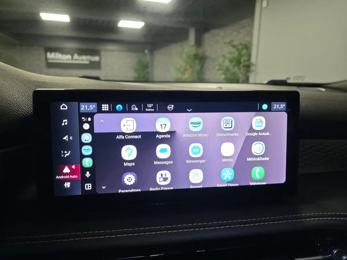 Écran tactile central affichant Android Auto dans l'habitacle de l'Alfa Romeo Tonale rouge, vue intérieure frontale.