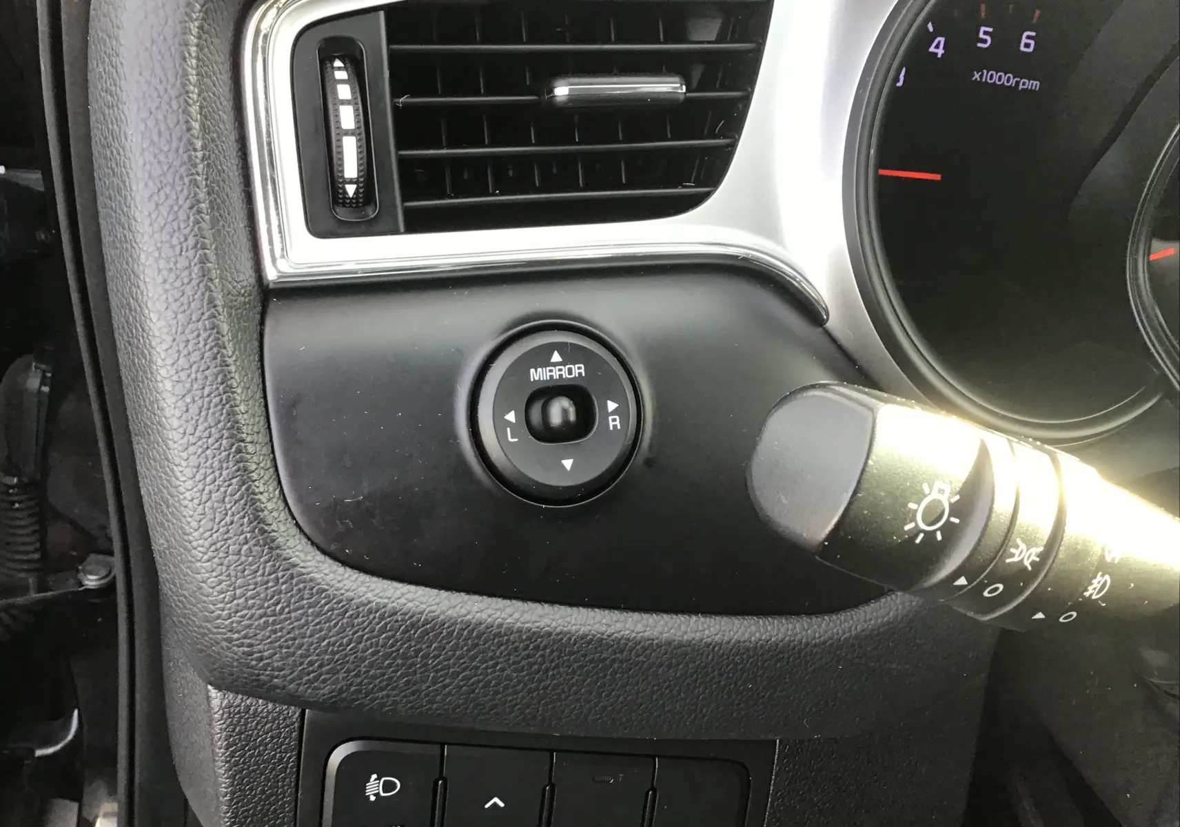 Détail du tableau de bord côté gauche d'une KIA CEE'D SW noire 2017, avec commandes des rétroviseurs et éclairage visibles.