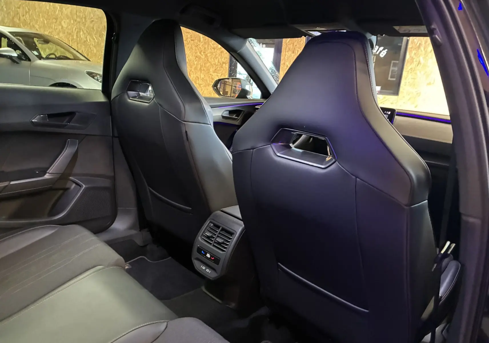 Vue arrière intérieure du CUPRA Formentor noir 2023, mettant en valeur les sièges sport et la console centrale avec ventilation.