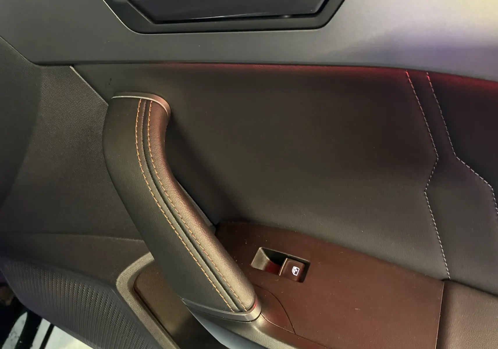Détail de la poignée de porte intérieure côté gauche en cuir noir avec surpiqûres contrastantes sur CUPRA Formentor 2023.