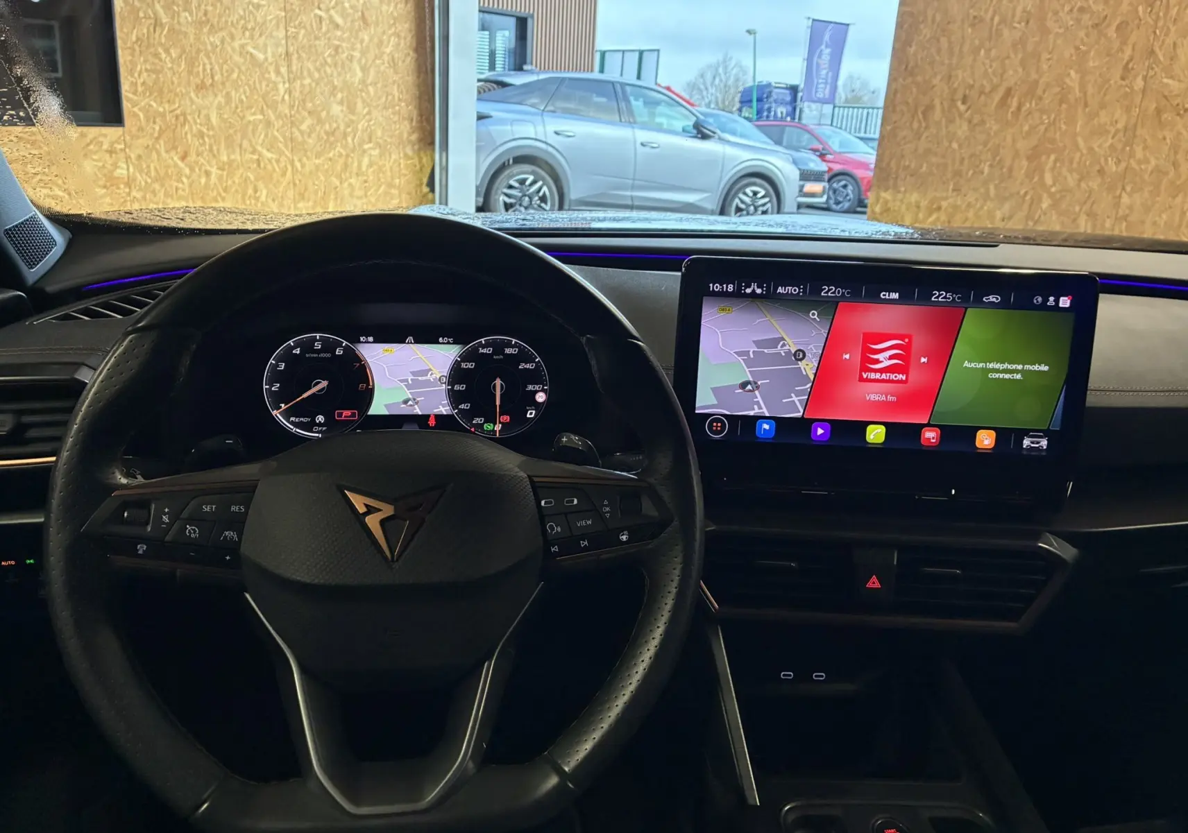 Vue intérieure du tableau de bord et volant noir du CUPRA Formentor 1.4 E-HYBRID avec écran tactile central allumé.