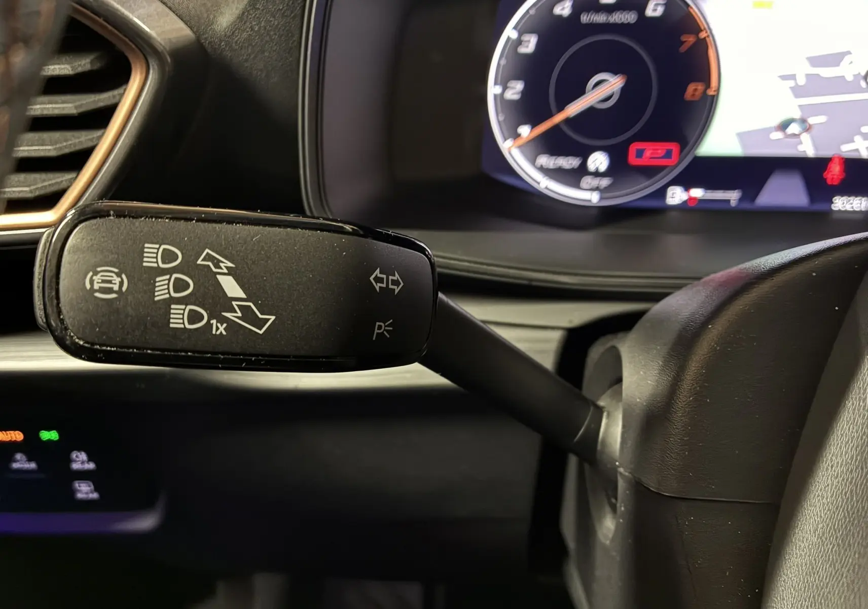 Gros plan sur le commodo gauche noir du tableau de bord du CUPRA Formentor 1.4 E-HYBRID 2023 avec compteur numérique en arrière-plan.