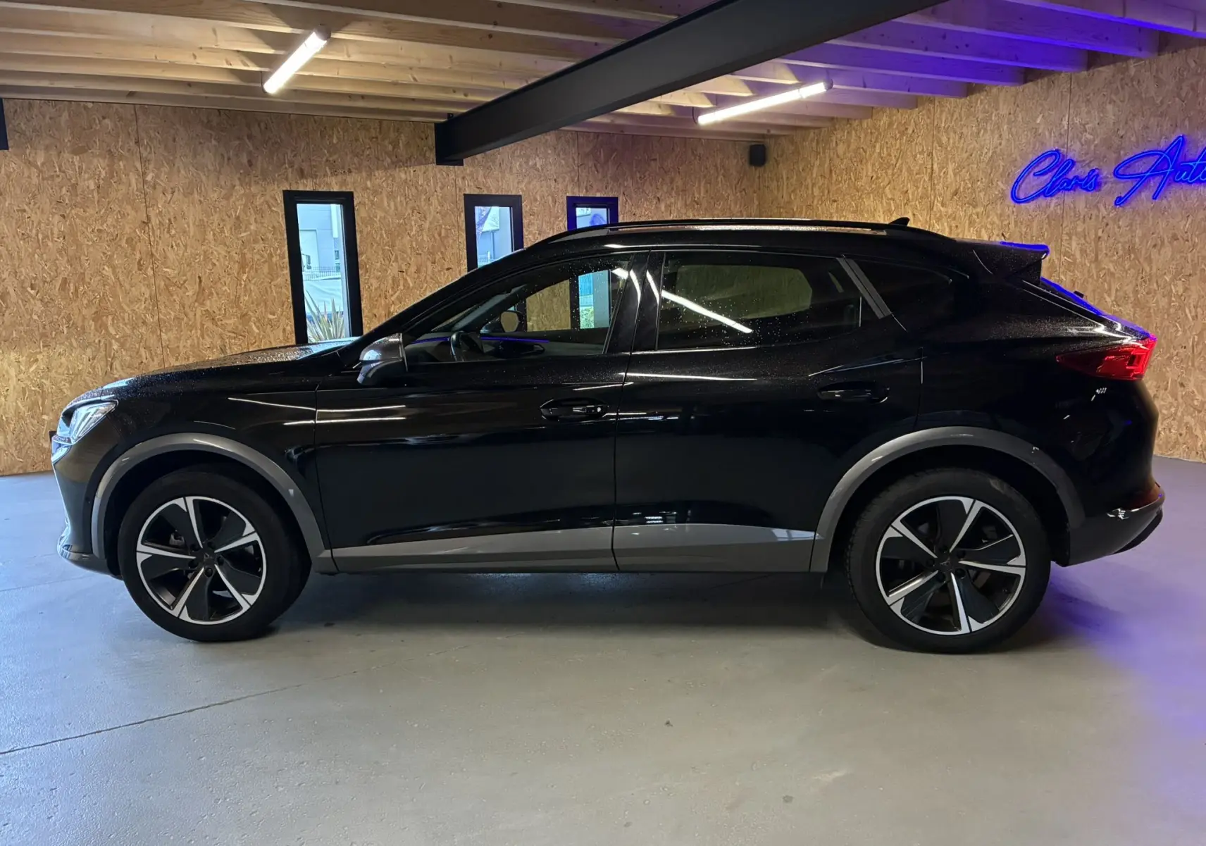 Vue de profil côté gauche d'un CUPRA Formentor noir 2023 hybride rechargeable avec jantes alliage distinctives.