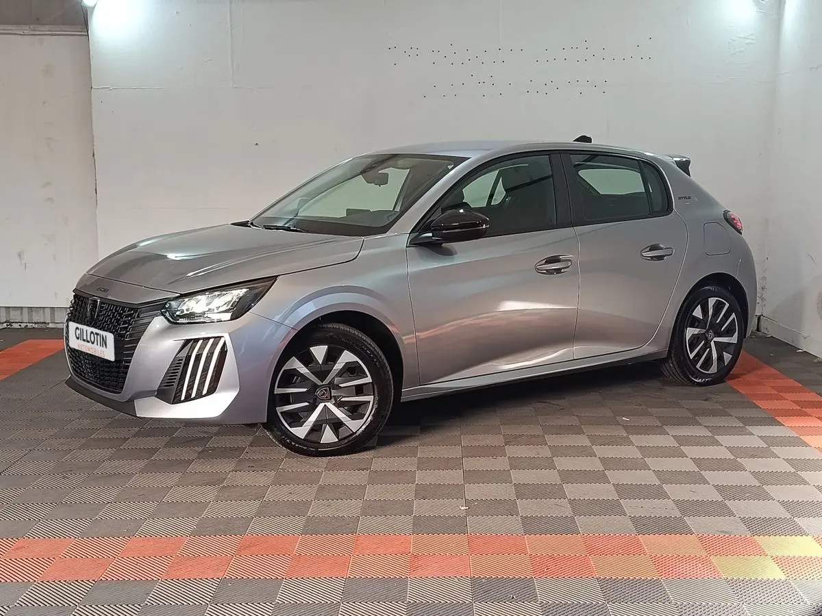 Peugeot 208 Hybrid gris clair vue 3/4 avant droit, avec jantes stylisées et feux LED distinctifs.