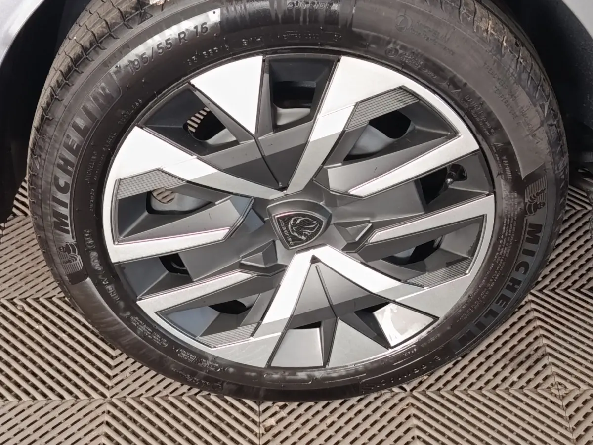 Gros plan sur la jante alliage bicolore gris et argent avec logo Peugeot au centre, montée sur pneu Michelin.