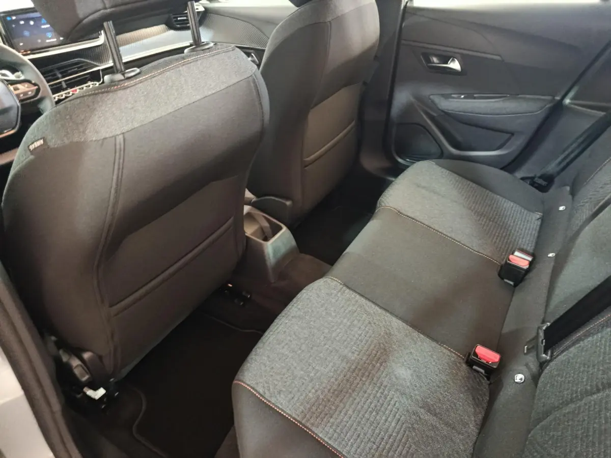 Vue intérieure arrière droite de la banquette tissu gris foncé et clair de la Peugeot 208 Hybrid 2025.
