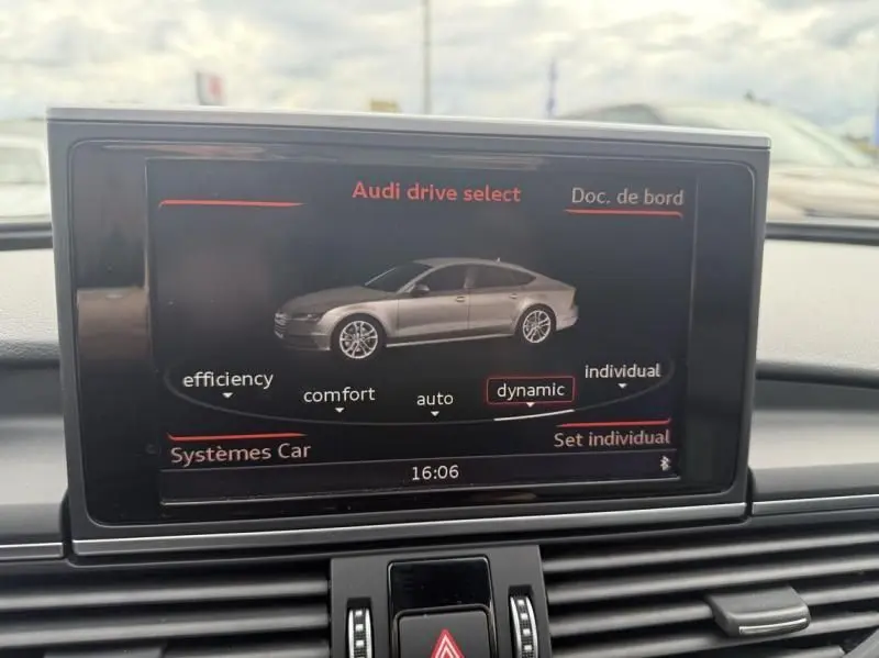 Écran central montrant le mode Audi drive select avec une vue latérale droite stylisée de l'Audi A7 Sportback blanc 2018.