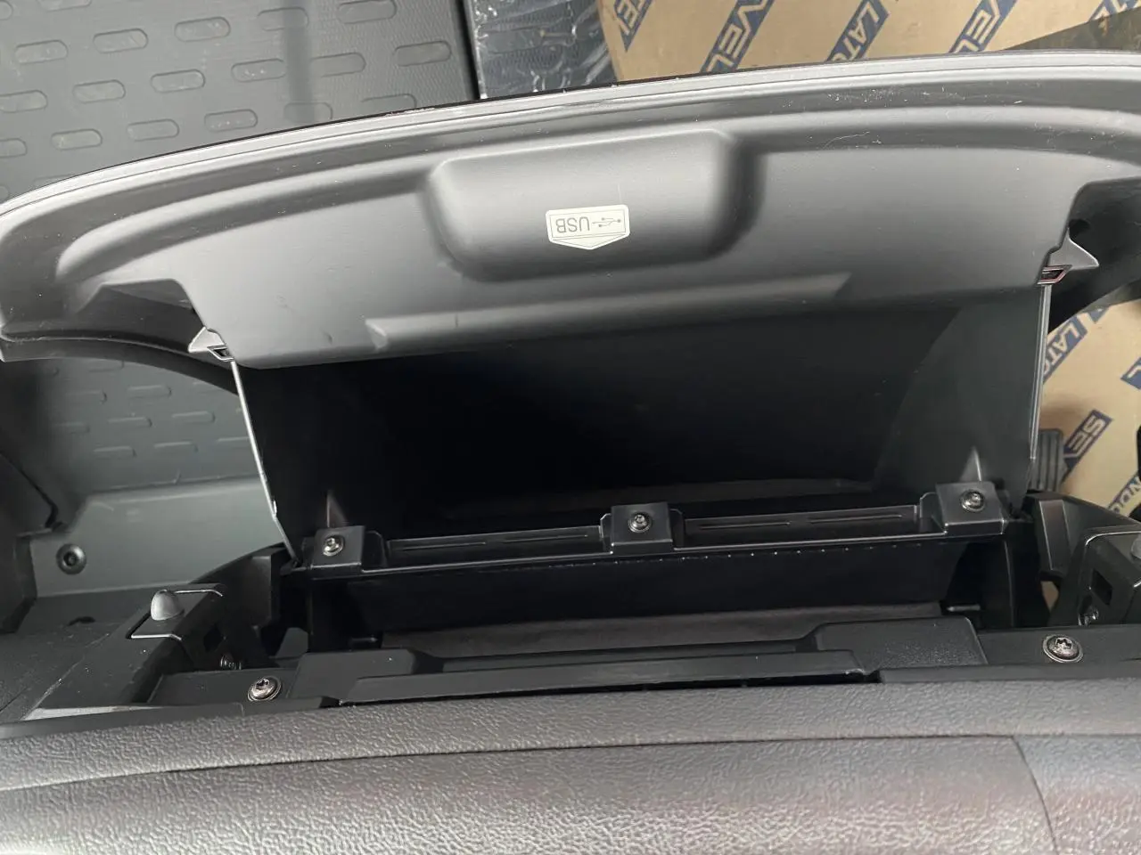 Compartiment de rangement ouvert avec port USB visible sur le tableau de bord noir de l'Opel Movano Fourgon 2022.