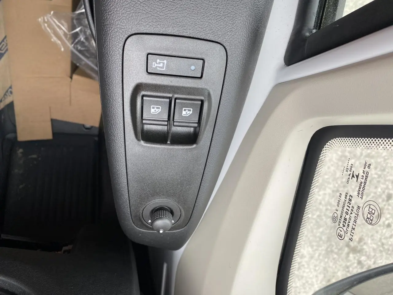 Détail des commandes de réglage des rétroviseurs et vitres côté conducteur dans un Opel Movano Fourgon blanc 2022.