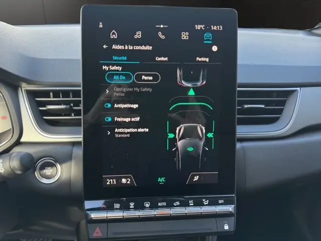 Écran central tactile du tableau de bord du Renault Captur 2025, affichant les aides à la conduite et commandes climatisation.