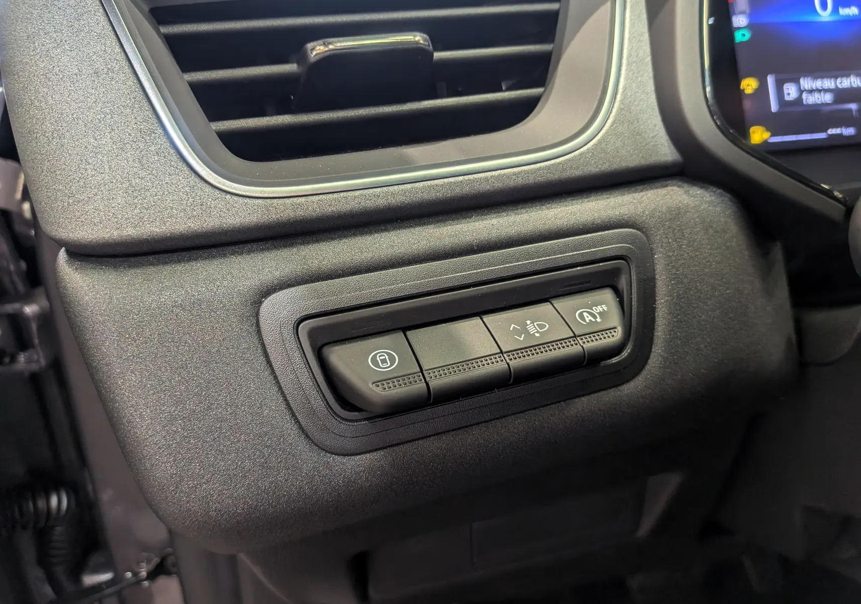 Gros plan sur les commandes de réglage des feux et fonction start/stop du tableau de bord du Renault Captur gris Cassiopé 2025.