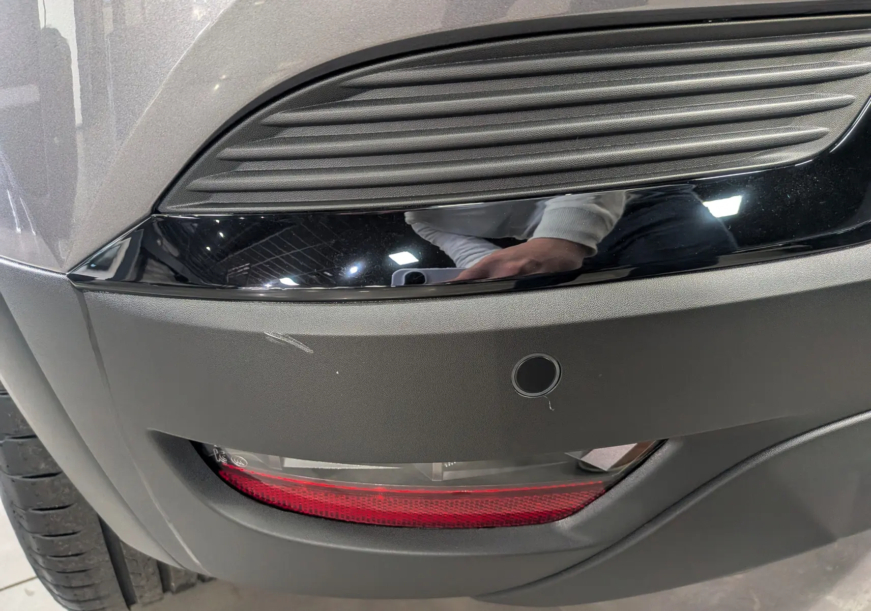 Gros plan sur le feu arrière droit et le pare-chocs gris cassiopé du Renault Captur 2025 avec insert noir brillant.