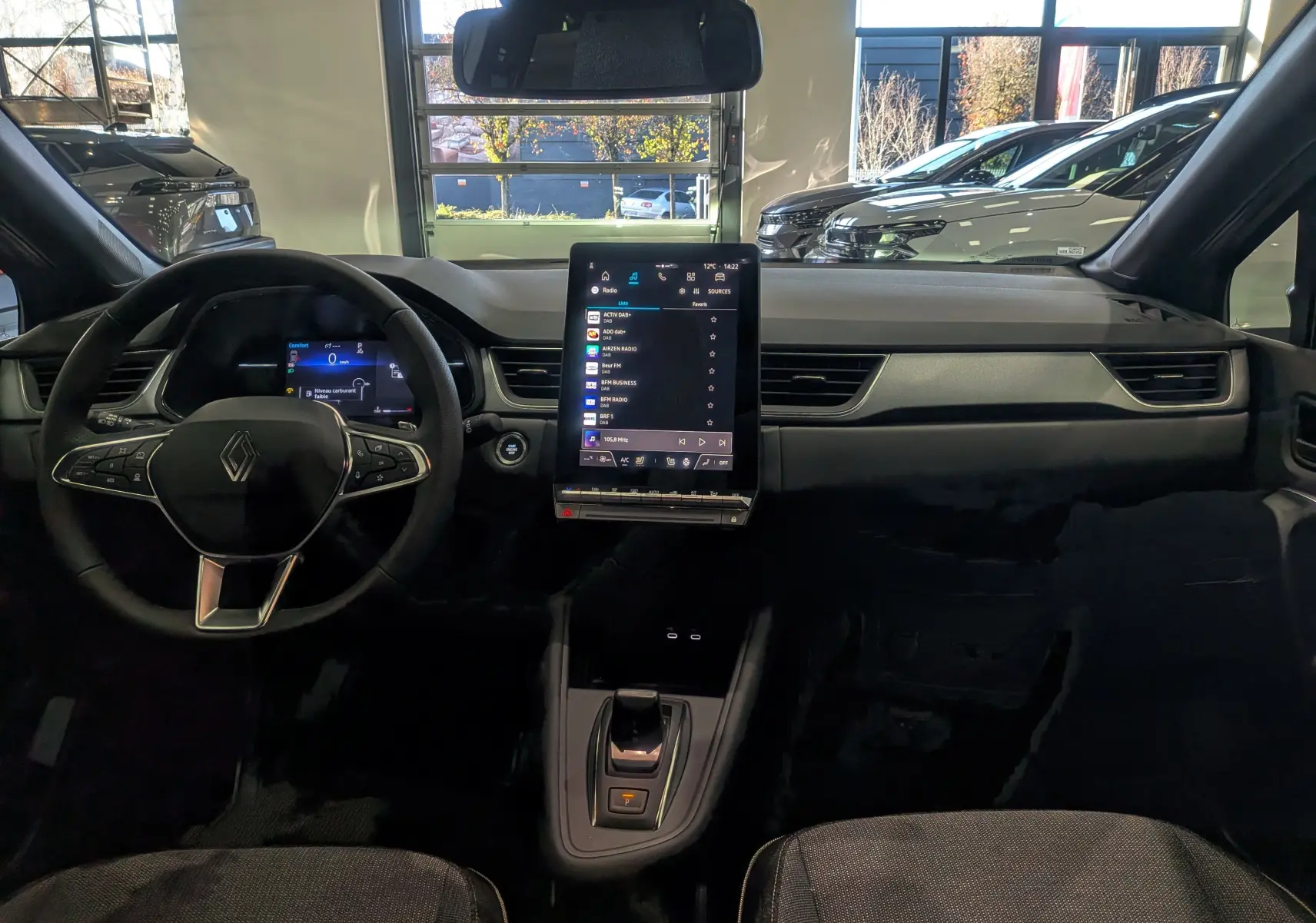 Intérieur du Renault Captur 2025, vue frontale du tableau de bord avec écran tactile vertical et volant multifonction noir.