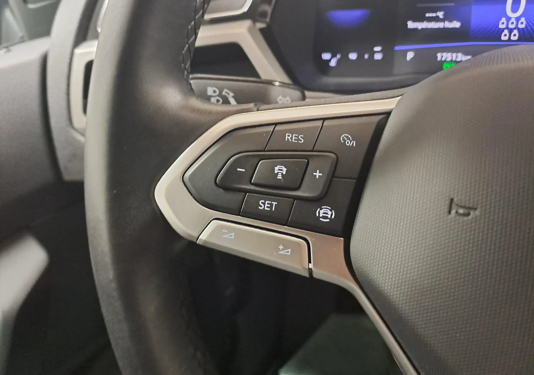 Gros plan sur les commandes au volant à gauche du Volkswagen Touran 2024, boutons de régulateur de vitesse et assistance conduite.