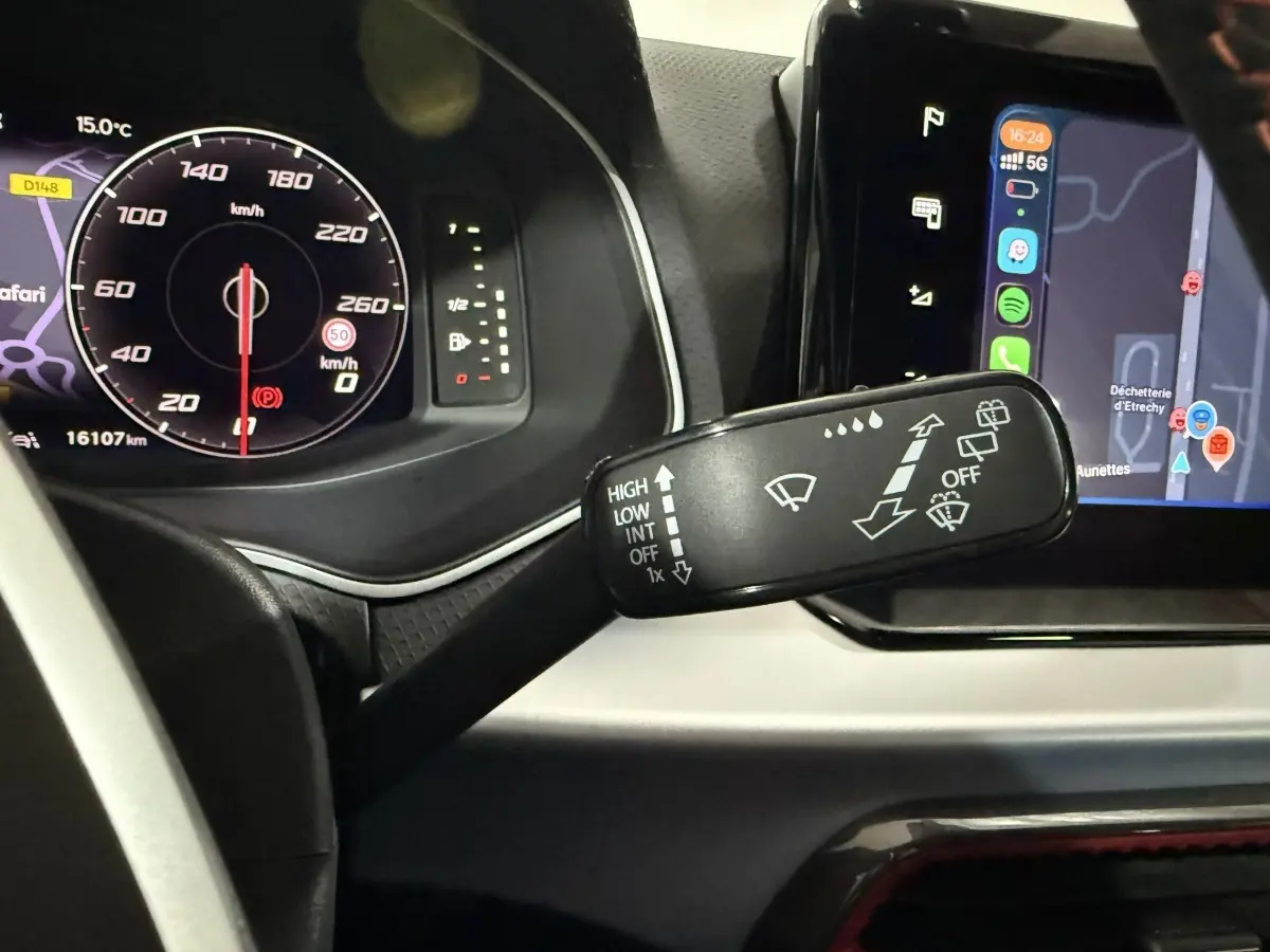 Gros plan sur la commande d’essuie-glaces à gauche du volant dans l’habitacle gris foncé de la SEAT Ibiza 2024.