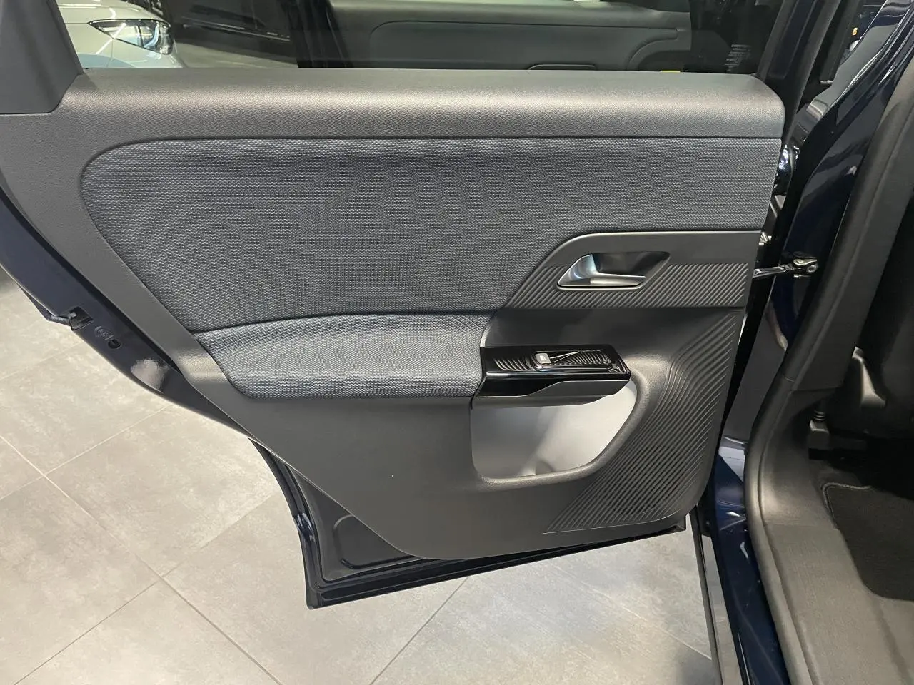 Vue intérieure de la porte arrière gauche bleu azul du Citroën C5 Aircross 2026 avec habillage textile et plastique noir.
