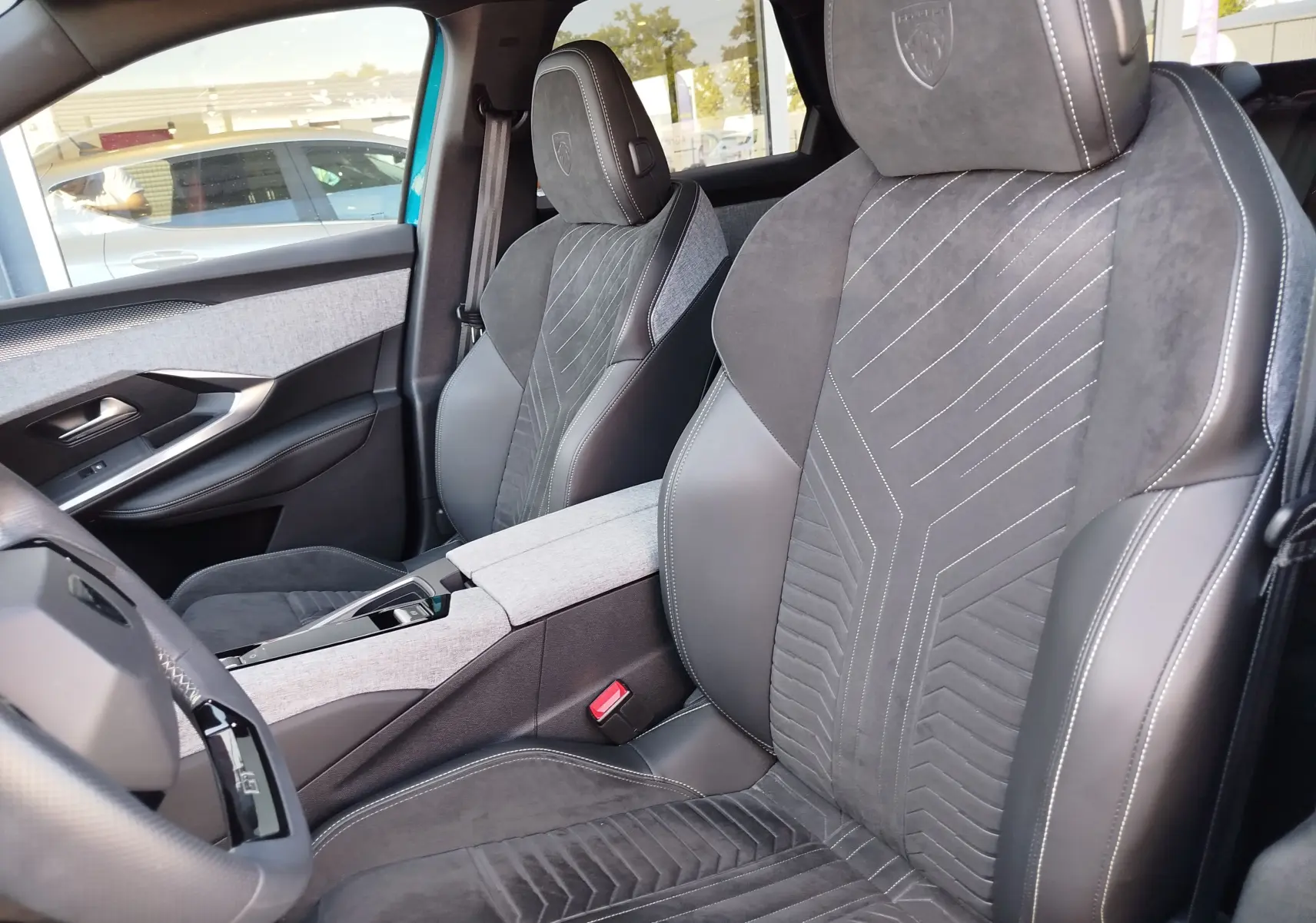 Vue intérieure côté conducteur du Peugeot 3008 2024 bleu Obsession, sièges sport en cuir et alcantara avec surpiqûres blanches.