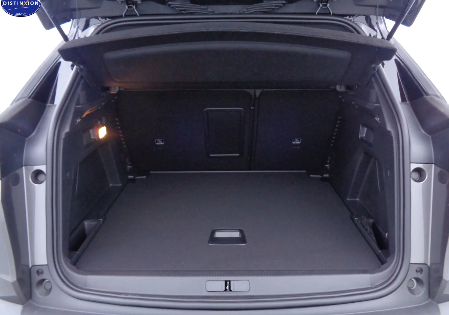 Coffre ouvert du Peugeot 3008 gris platinium métal, vue arrière montrant un espace de chargement spacieux et bien éclairé.